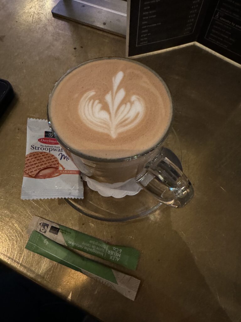 Beautiful latte displayed with a mini stroopwafel