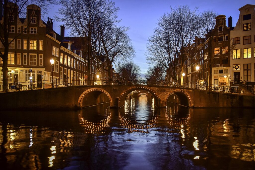 Amsterdam Canal at Night, with three light arches under a bridge